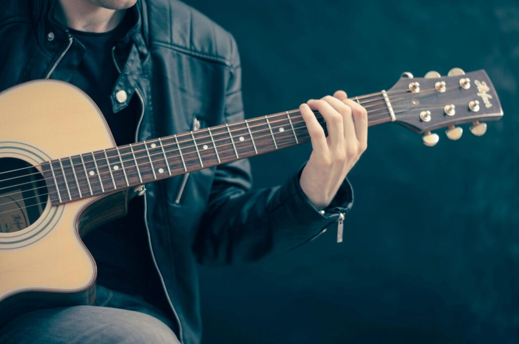 a closeup of a man holding a guitar