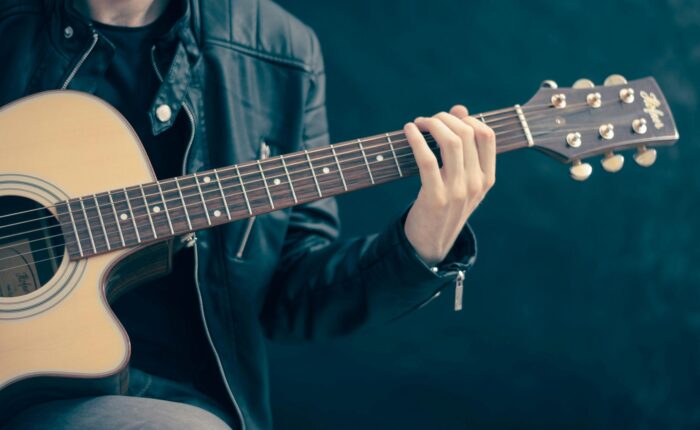 a closeup of a man holding a guitar